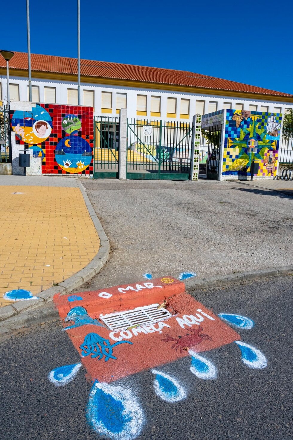 Sarjeta pintada com a escola em fundo