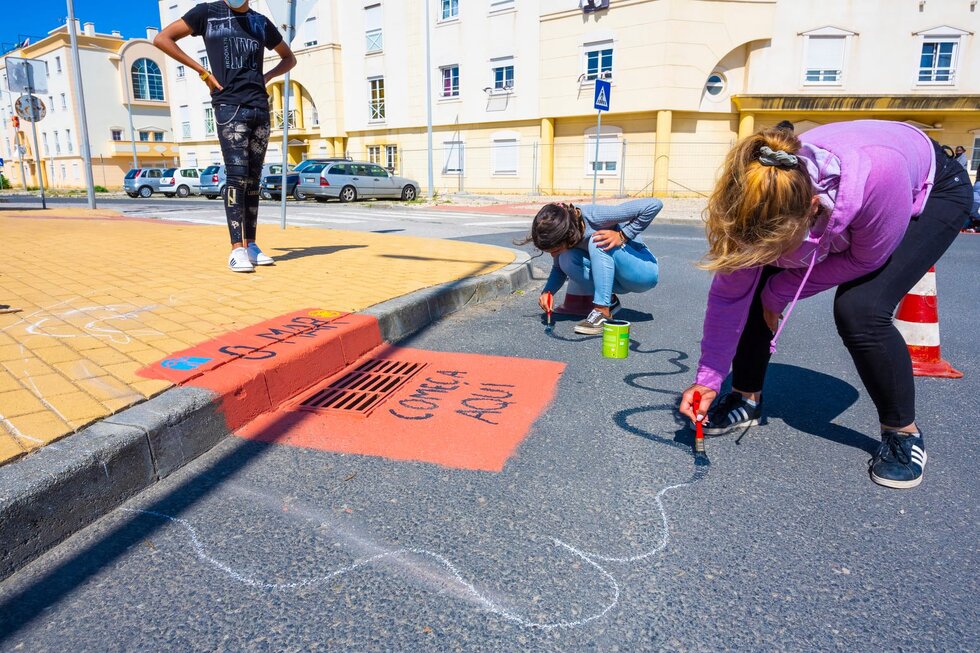 Alunos a pintar sarjeta
